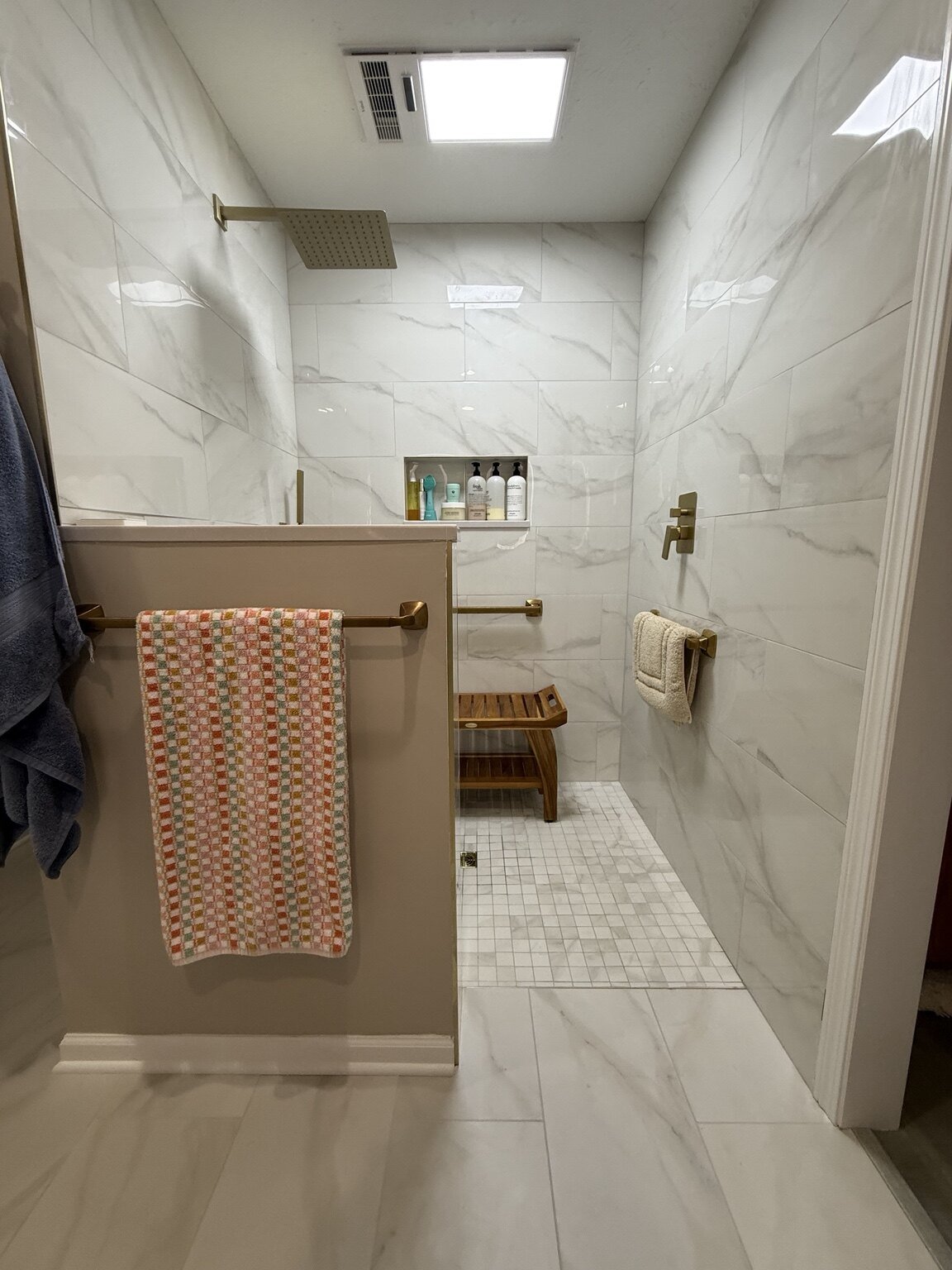 Custom accessible walk-in shower with tile walls and built-in seating by Hukill Tile & Design